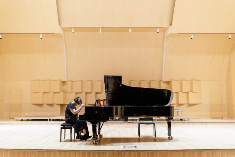 Adriana Toacsen interpretând o piesă la pian.